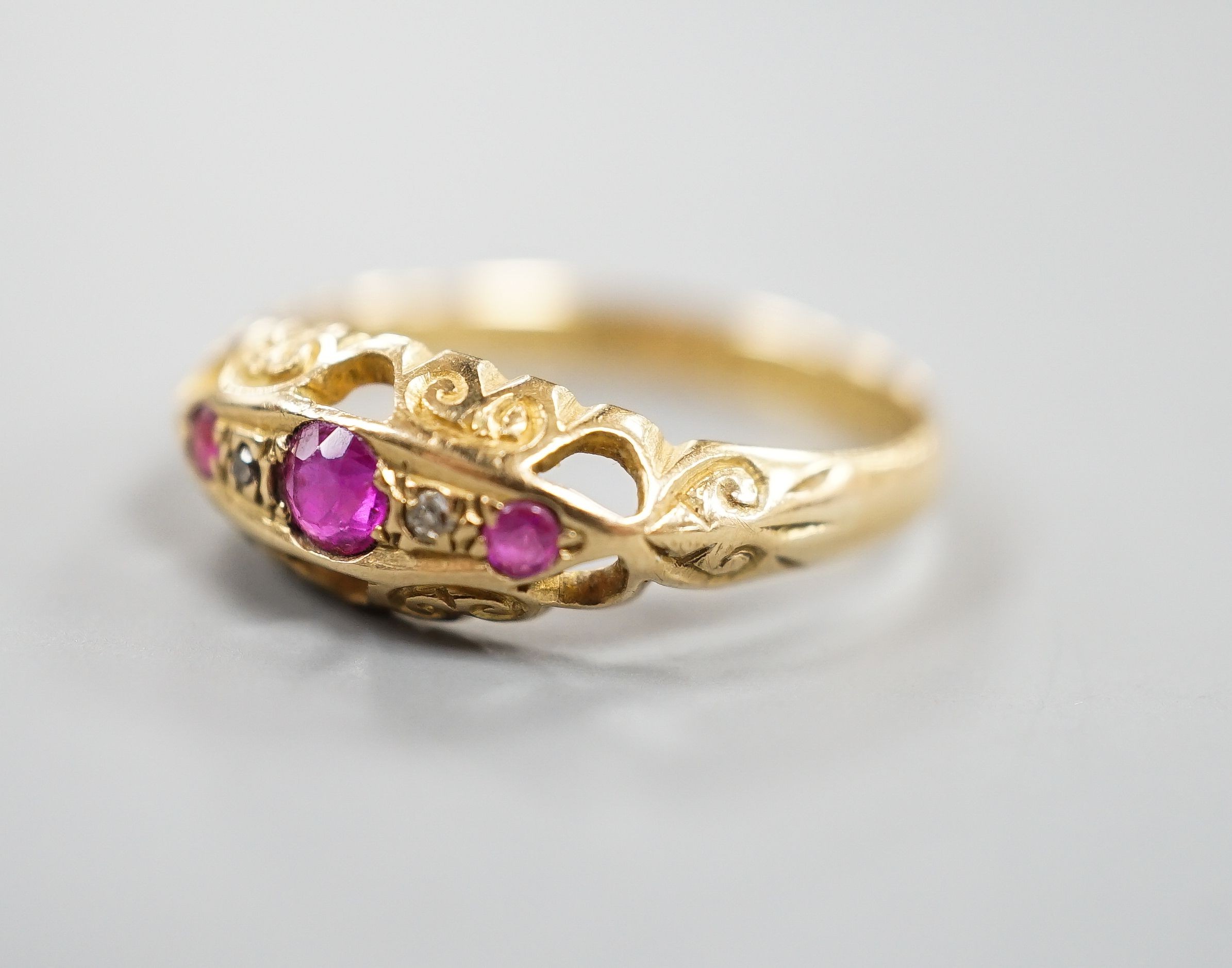 A George V 18ct gold three stone ruby and two stone diamond chip set ring, size Q, gross weight 3 grams.